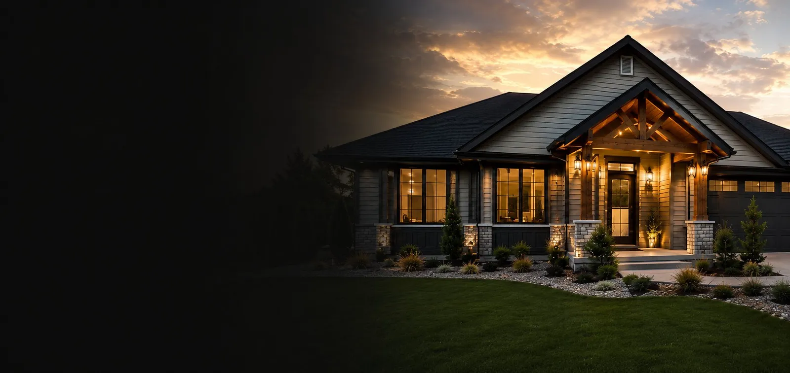Craftsman-style home at dusk with warm lit windows, stone porch columns, and a manicured lawn
